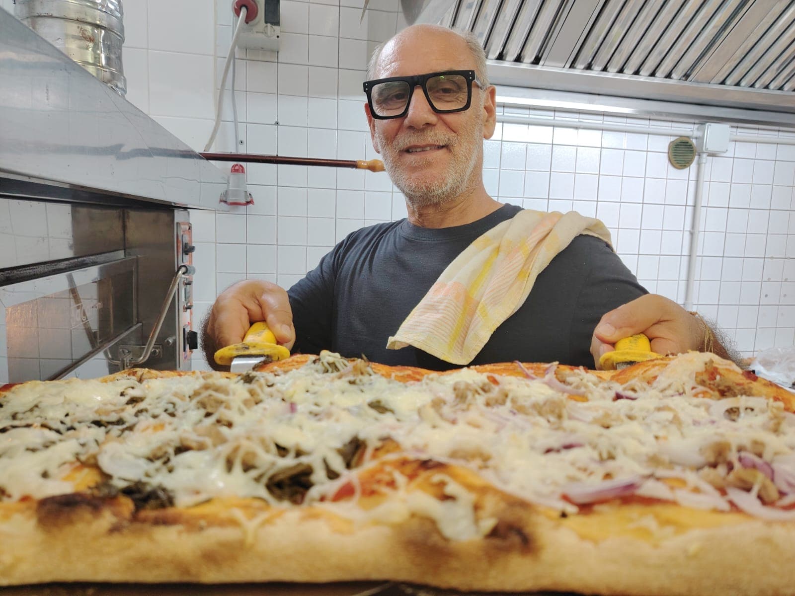 Il pizzaiolo de La Lanterna con una pizza appena sfornata